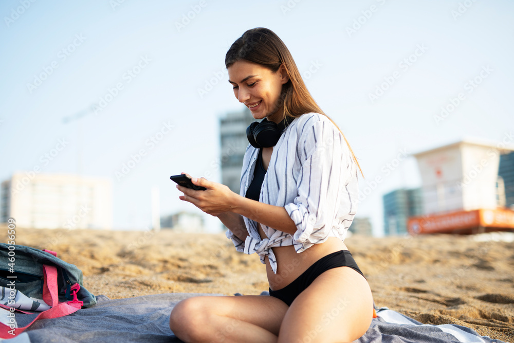 Happy young woman relaxing on the sandy beach. Beautiful woman enjoying a summer day on the beach