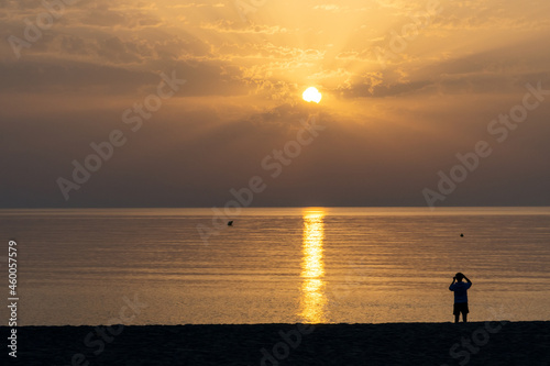Fototapeta Naklejka Na Ścianę i Meble -  Person taking sunrise photography on a cloudy day