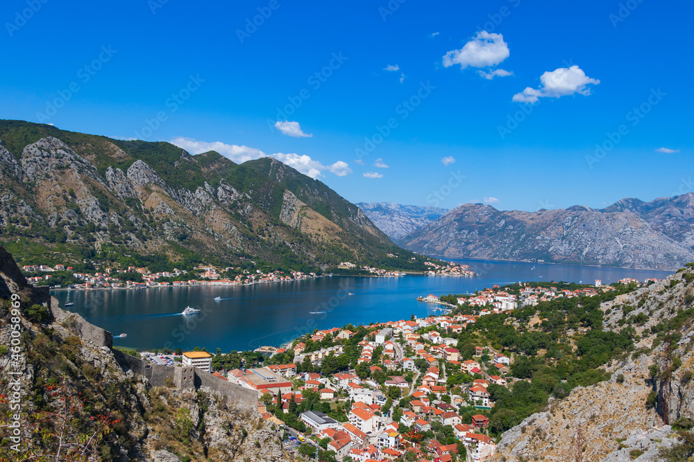 Scenic panoramic view on the way up the hill to the fortress of St. John.Part of the fortress wall is visible in the foreground. Below you can see the city of Kotor with red roofs and the Bay of Kotor