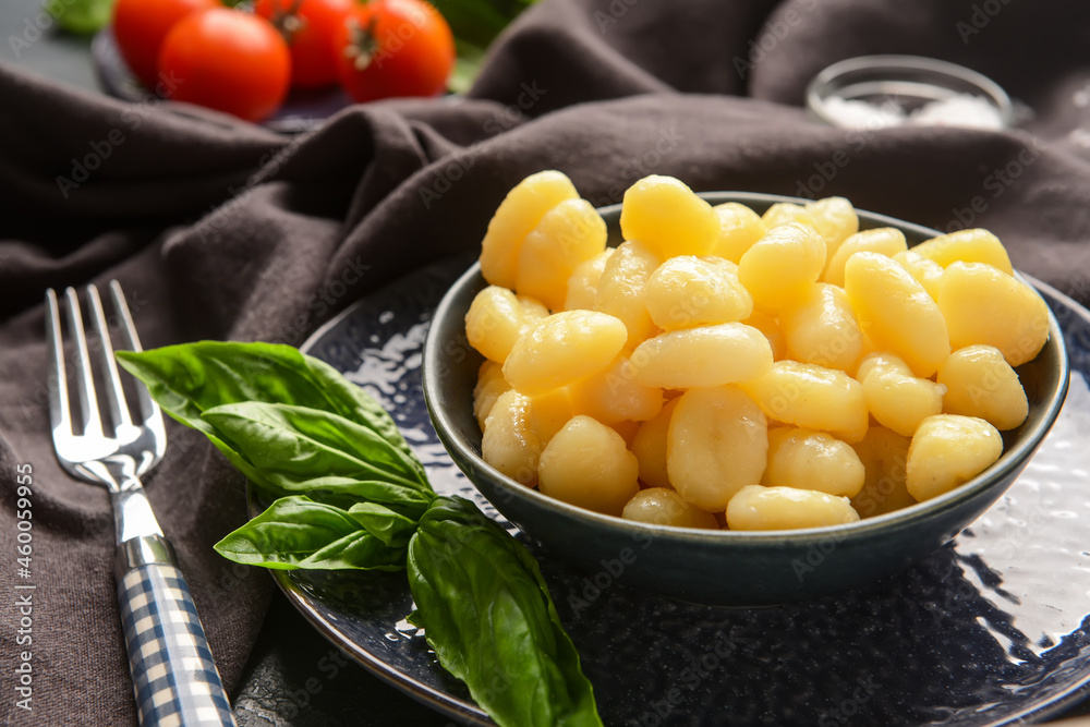 Bowl with tasty gnocchi on dark background Bowl with tasty gnocchi on dark background