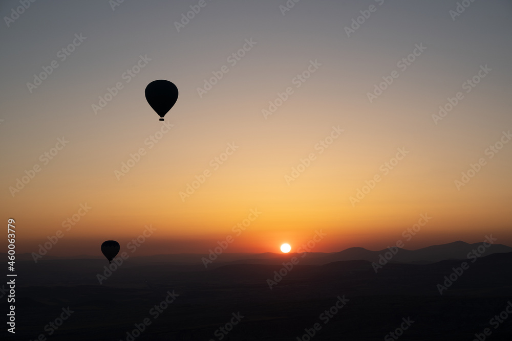 hot air balloon silhouettes with sun rising over the mountains hot air balloon silhouettes with sun rising over the mountains