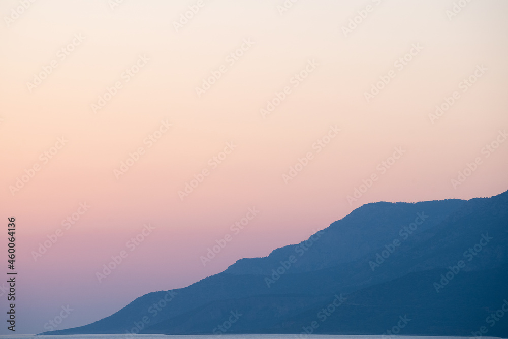 Fototapeta krajobraz gór i morza o zachodzie słońca