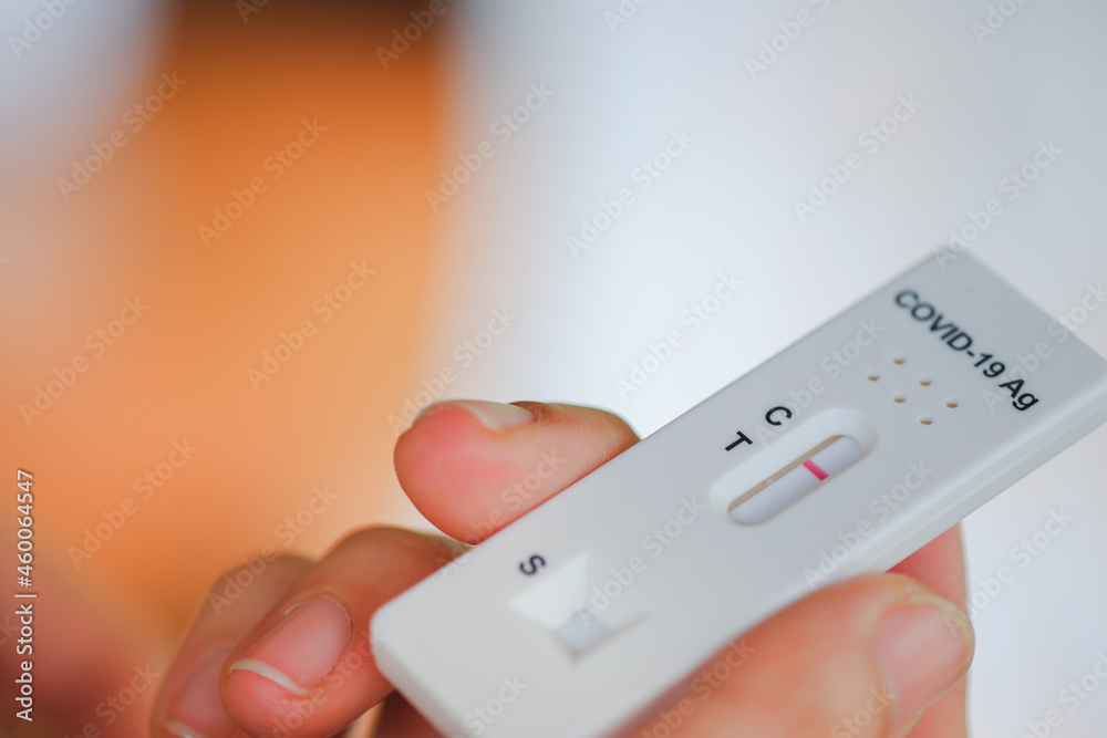 Woman's hand holding antigen test kit for covid 19 with blurred background, Selective focus. Woman's hand holding antigen test kit for covid 19 with blurred background, Selective focus.