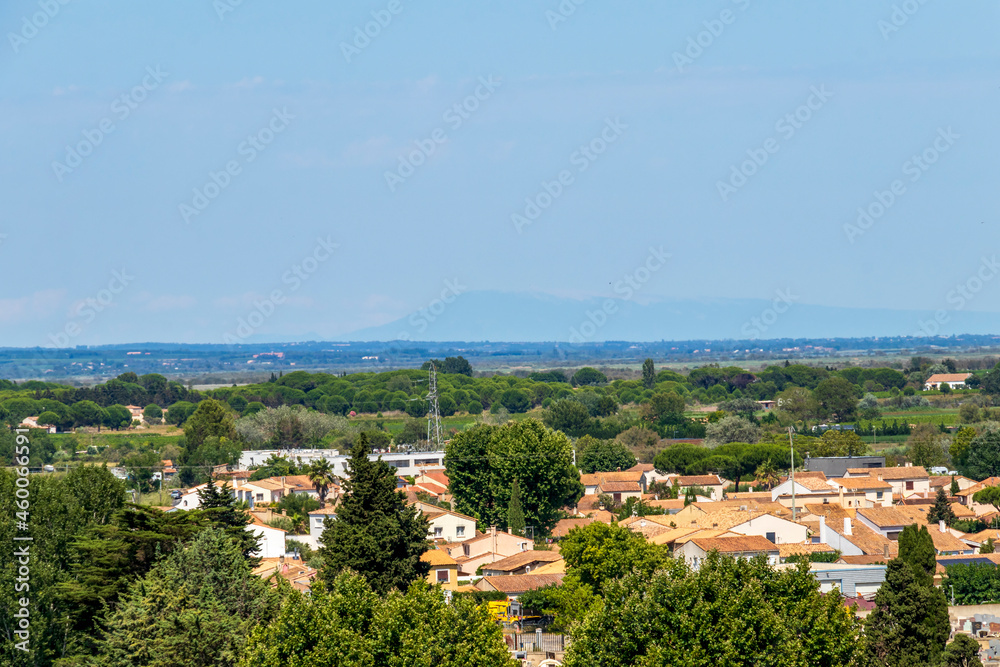 Aigues-Mortes medieval town red tailed rooftops and Mont Ventoux silhouette on the background, France