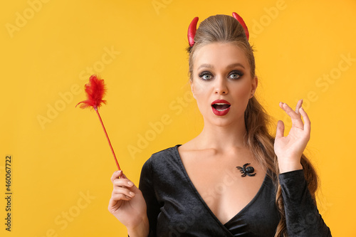 Sexy young woman dressed for Halloween party on color background
