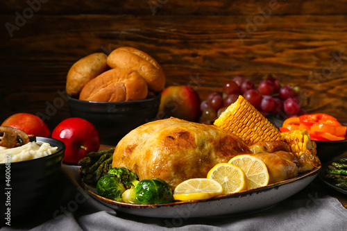 Tasty baked turkey with lemon and vegetables for Thanksgiving Day on wooden background