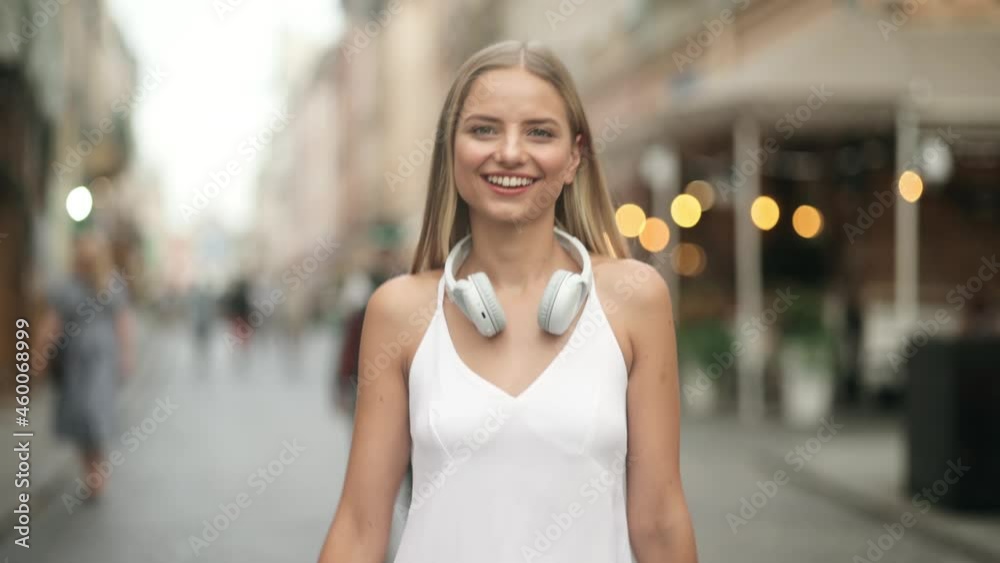 Portrait young attractive smile woman look at camera at city center. Outdoor portrait happy female tourist having good time wandering around town in summer. Portrait young attractive smile woman look at camera at city center. Outdoor portrait happy female tourist having good time wandering around town in summer.