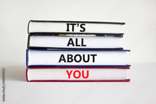 It is all about you symbol. Books with words 'It is all about you'. Beautiful white background. Businessman hand. Copy space. Business and it is all about you concept. photo