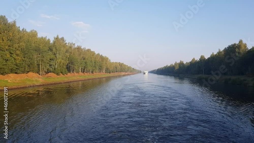 Picturesque river landscape with green trees in early autumn. View from the ship's porthole