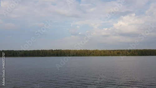 Picturesque river landscape with green trees in early autumn. View from the ship's porthole