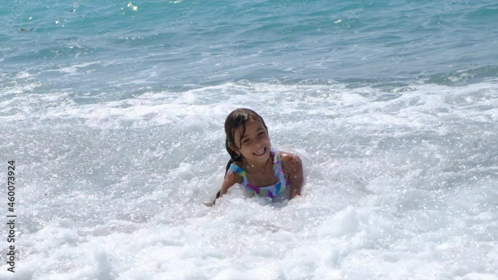 The child swims in the sea with waves. Selective focus. The child swims in the sea with waves. Selective focus.