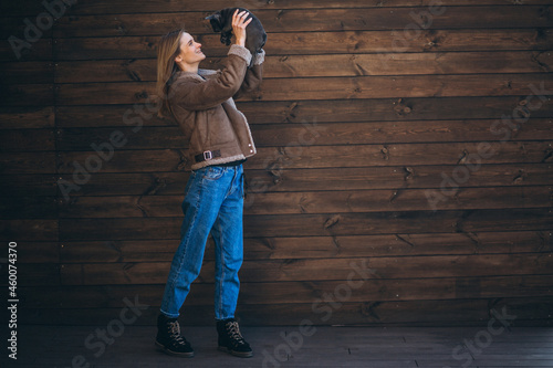 Woman with her pet french bulldog on wooden background