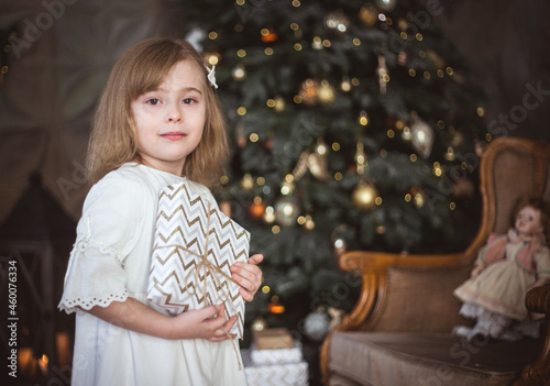 Cute little girl with a Christmas present in her hands. Winter holidays, christmas and new year.
