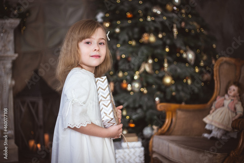 Cute little girl with a Christmas present in her hands. Winter holidays, christmas and new year.