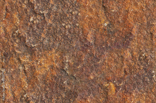 Brown stone rough seamless texture surface with orange inclusions macro