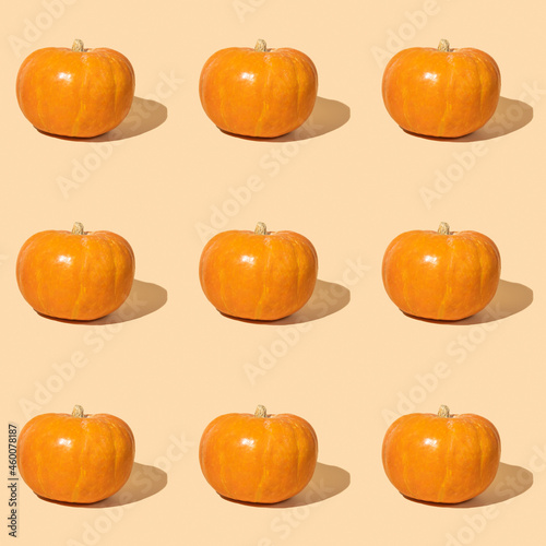 Seamless pattern with orange pumpkin on yellow background.