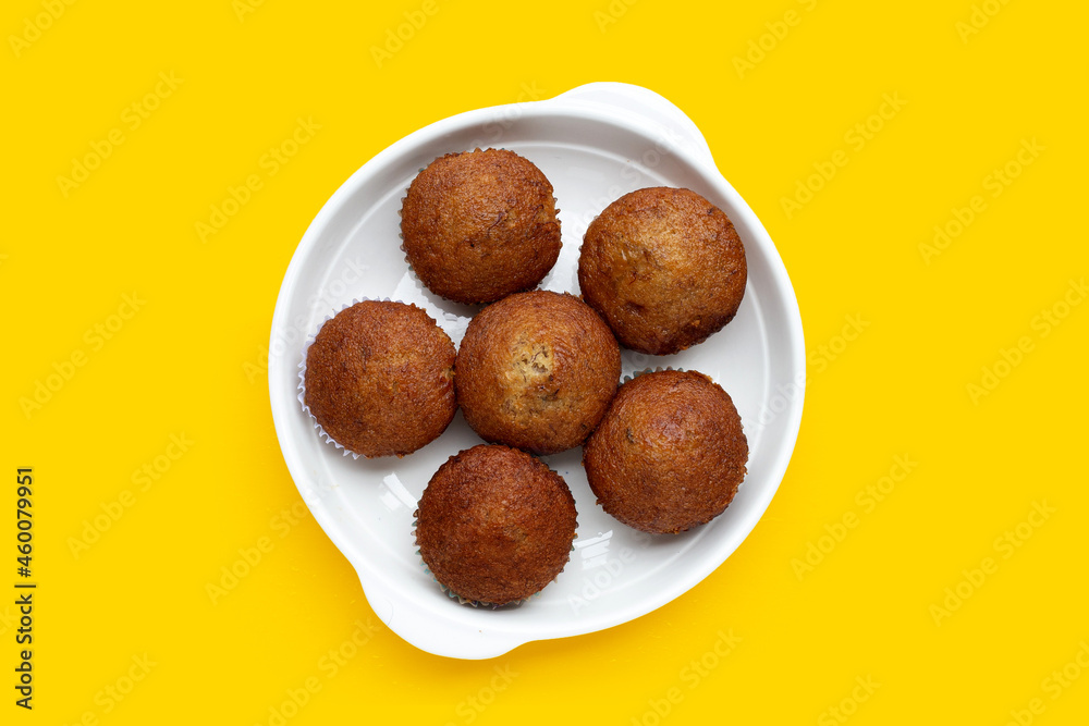 Banana Cupcakes in white plate on yellow background. Banana Cupcakes in white plate on yellow background.