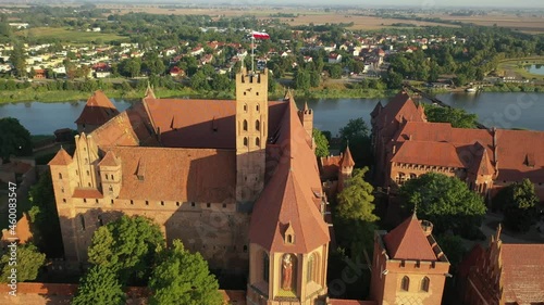 Malbork,Poland.Aerial 4K video from drone to Medieval Malbork ( Zamek w Maborku, Ordensburg Marienburg ),castle in Poland fortress of the Teutonic Knights at the Nogat river in sunrise light.(Series) photo