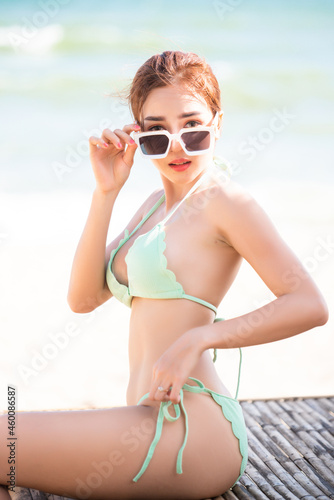 Young pretty sexy asian woman in bikini on tropical beach. summer vacation.