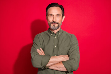 Photo portrait man wearing casual clothes smiling crossed hands isolated vivid red color background