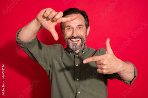 Photo of cool mature brunet man hands face wear green shirt isolated on red color background