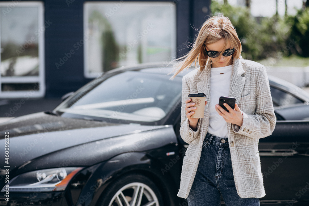 Young happy woman drinking coffee by the car Young happy woman drinking coffee by the car