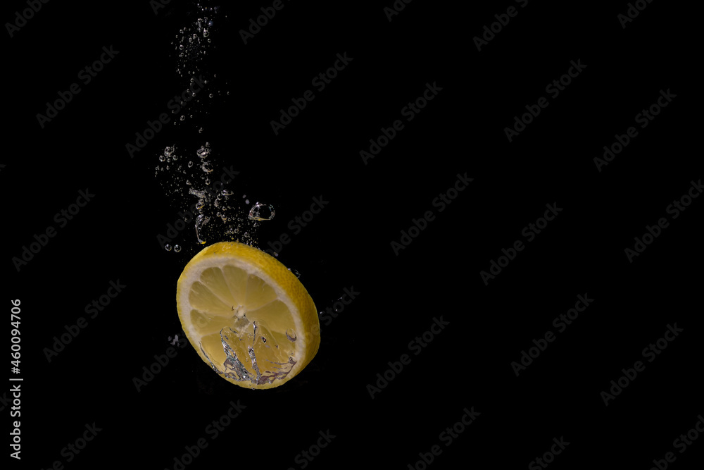 Fresh fruit fall into the cold water with air bubbles as symbol for healthy vegan lifestyle in short time exposure of high speed camera