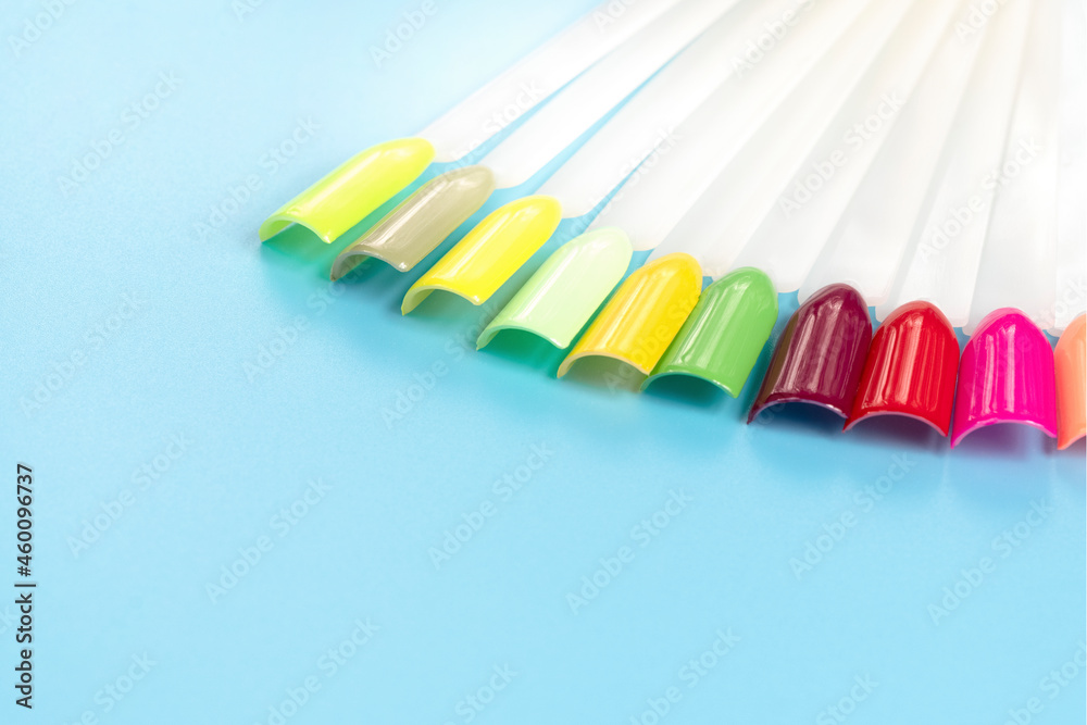 Multiсolor nail tips on a blue background. examples of manicure for nails. Palette with color samples of nail. Copy space Multiсolor nail tips on a blue background. examples of manicure for nails. Palette with color samples of nail. Copy space