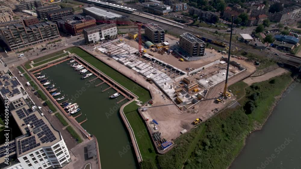 Aerial rotating pan showing construction site of luxury apartment Kade Zuid complex being build in former industrial area. Urban development and housing concept Aerial rotating pan showing construction site of luxury apartment Kade Zuid complex being build in former industrial area. Urban development and housing concept