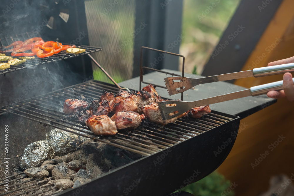 A barbecue grill with tasty juicy steaks are grilled over an open fire.
