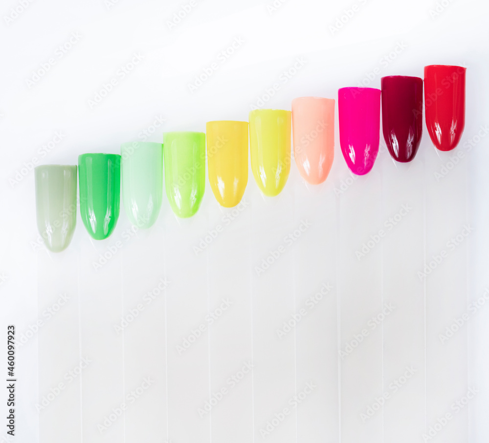 Fototapeta premium Multiсolor nail tips on a white background. examples of manicure for nails. Palette with color samples of nail. Copy space