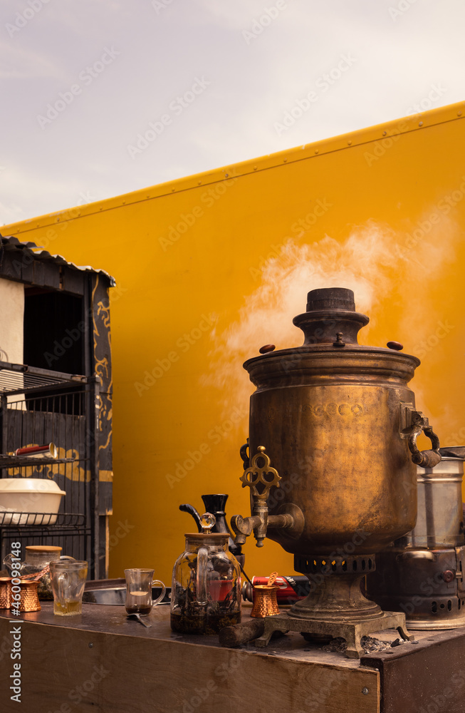 Old antique golden samovar. Vintage. White smoke, yellow wall. Drink tea