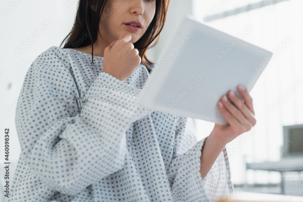 cropped view of brunette patient using digital tablet in clinic cropped view of brunette patient using digital tablet in clinic