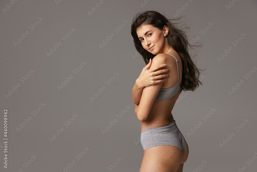 Half-length portrait of young beautiful slim woman in lingerie isolated over gray studio background. Natural beauty concept. Half-length portrait of young beautiful slim woman in lingerie isolated over gray studio background. Natural beauty concept.