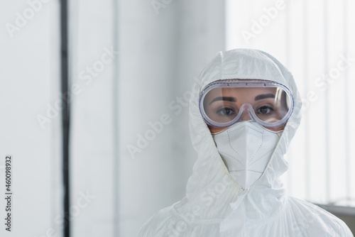 doctor in personal protective equipment and goggles looking at camera