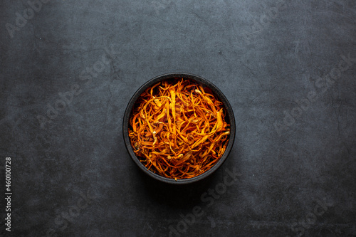 Dried cordyceps militaris mushroom in bowl on dark grey background. Cordyceps flower