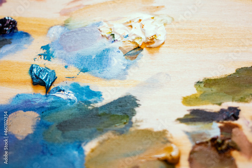 Oil paints. Artist's wooden palette with vibrant paint strokes. Beautiful art background.