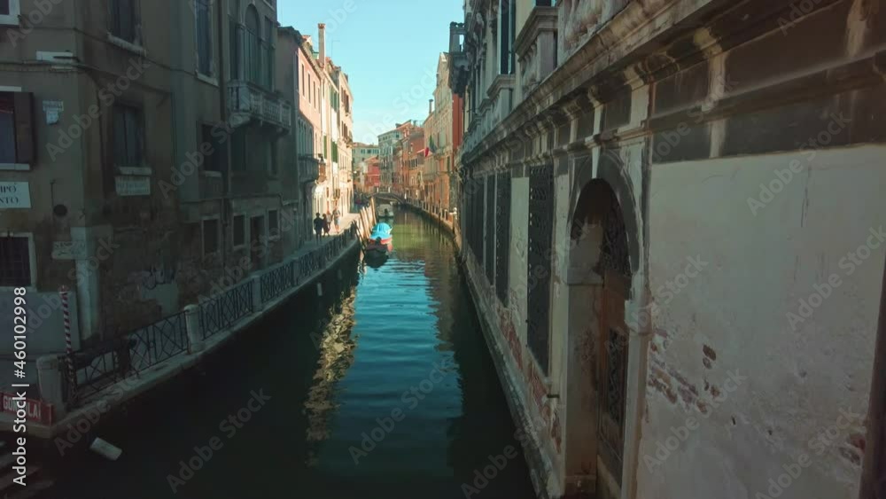 View over a small canal at a bridge in Venice. People walking near the canal in the summer. View over a small canal at a bridge in Venice. People walking near the canal in the summer.