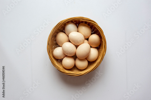 Fresh Chicken eggs in Bamboo basket on a white background.