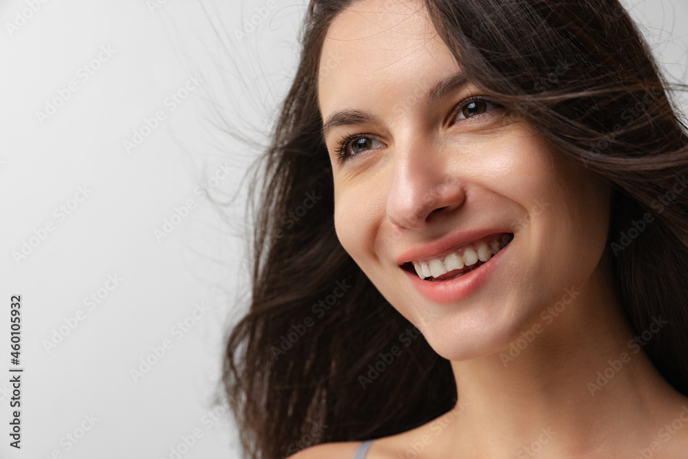 Close-up portrait of young beautiful smiling woman without makeup isolated over gray studio background. Natural beauty concept. Close-up portrait of young beautiful smiling woman without makeup isolated over gray studio background. Natural beauty concept.