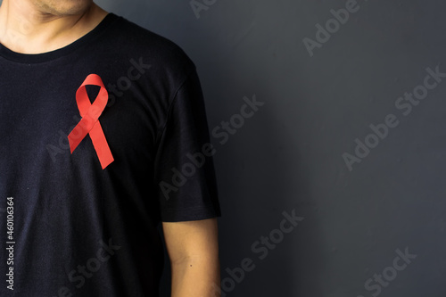 World Aids Day and World Diabetes Day with man wearing red AIDS awareness ribbon on chest. Healthcare and medicine concept. 