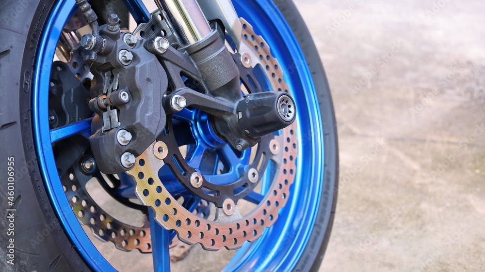 Close up brake and front wheel disc of motorcycle. Motorcycle radial mount caliper ABS braking system with copy space. selective focus Close up brake and front wheel disc of motorcycle. Motorcycle radial mount caliper ABS braking system with copy space. selective focus