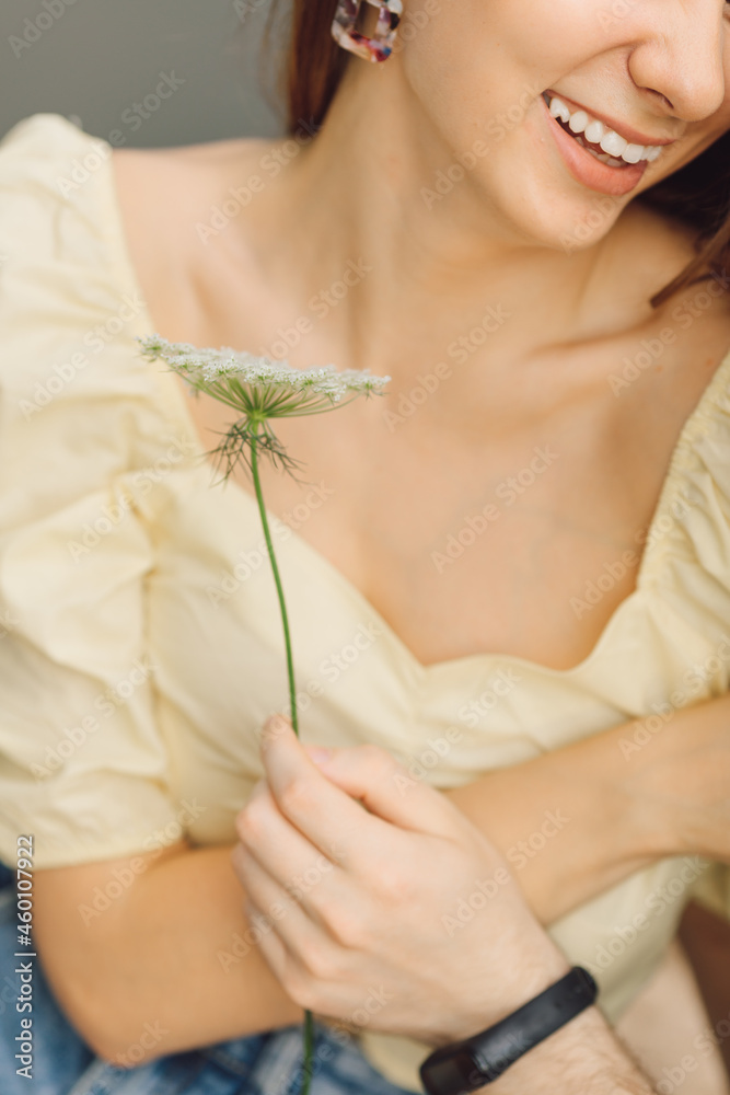 Obraz premium Portrait of young woman in summer clothes, to whom man gives wild flower. Beauty and health. Romantic relationships.Love and care. Wonderful moments of life. Body and skin care.