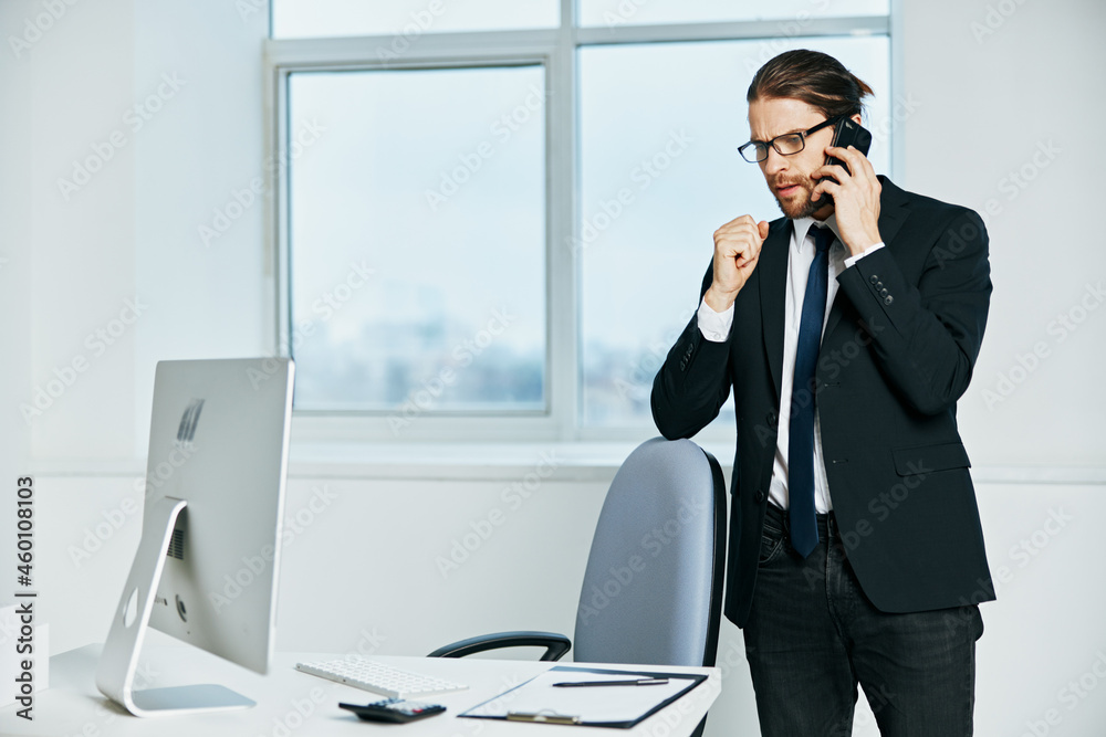male manager in a suit office work phone technologies male manager in a suit office work phone technologies