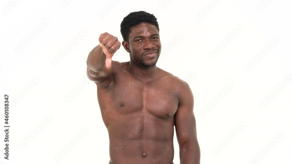 Portrait of a muscular black man showing thumbs down. Isolated on a white background,