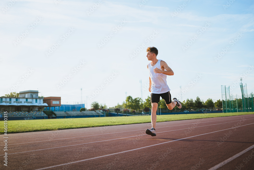 Runner jogging during workout on track in stadium Runner jogging during workout on track in stadium