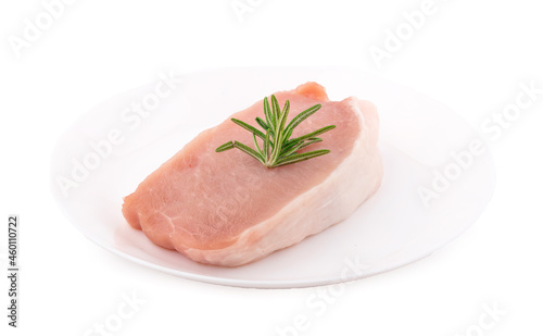 Raw pork in white plate on dark background