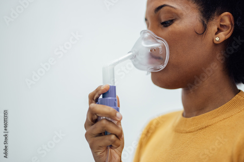 Close-up of a woman holding respiratory mask.