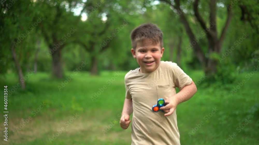 Child is Having Fun and Playing an Anti-Atress Toy. Kid is Playing Trendy Popular Game Toy Pop It in Garden. High quality 4k footage Child is Having Fun and Playing an Anti-Atress Toy. Kid is Playing Trendy Popular Game Toy Pop It in Garden. High quality 4k footage