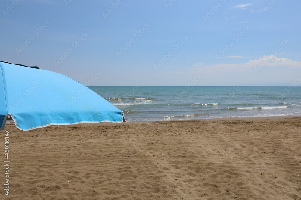 blue umbrella on the beach without people symbol of relaxation and summer vacation